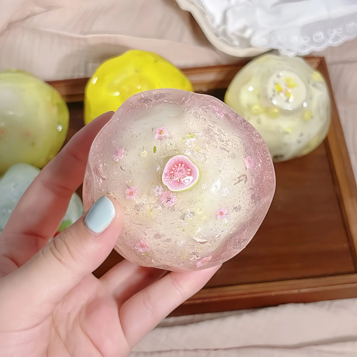 Pink guava and coconut crunchy squishy held in one hand