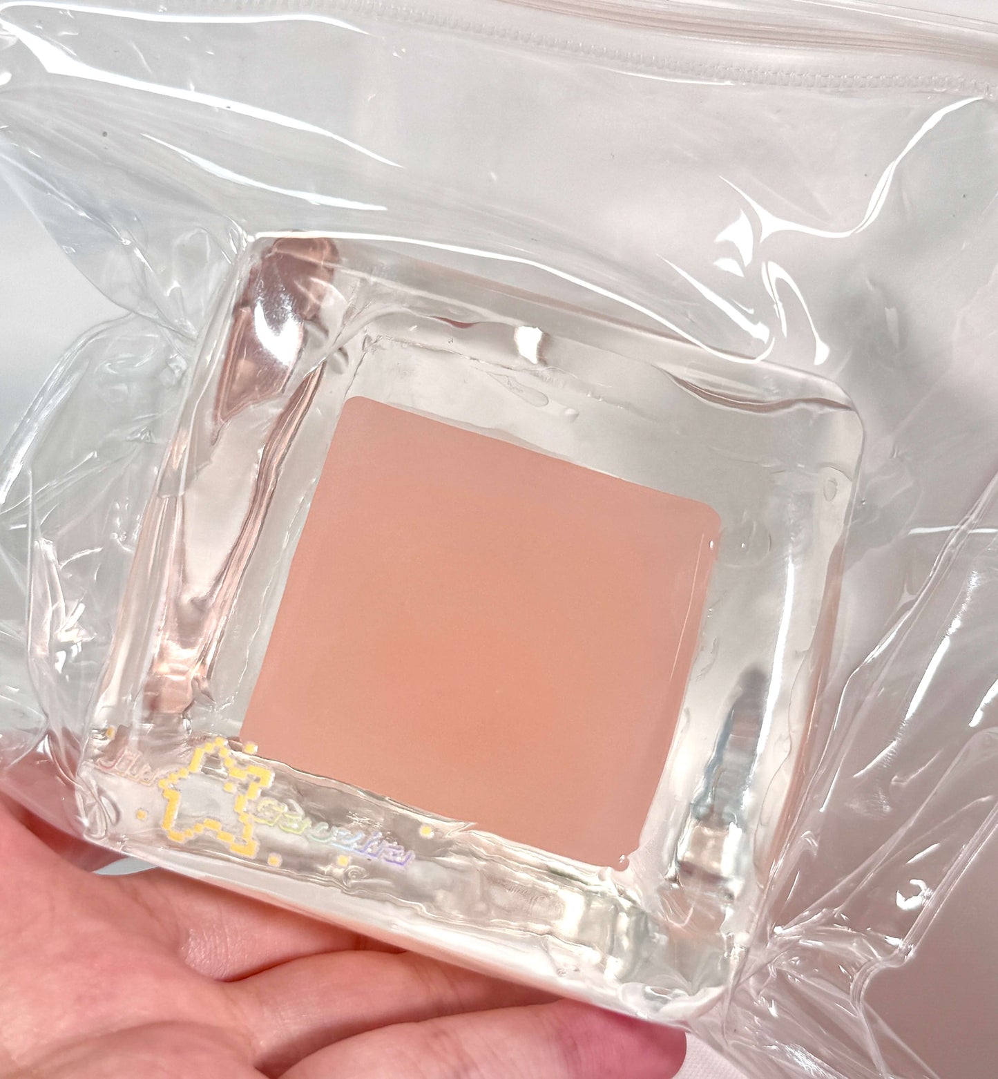 Pink grapefruit-colored soft ice block in clear packaging