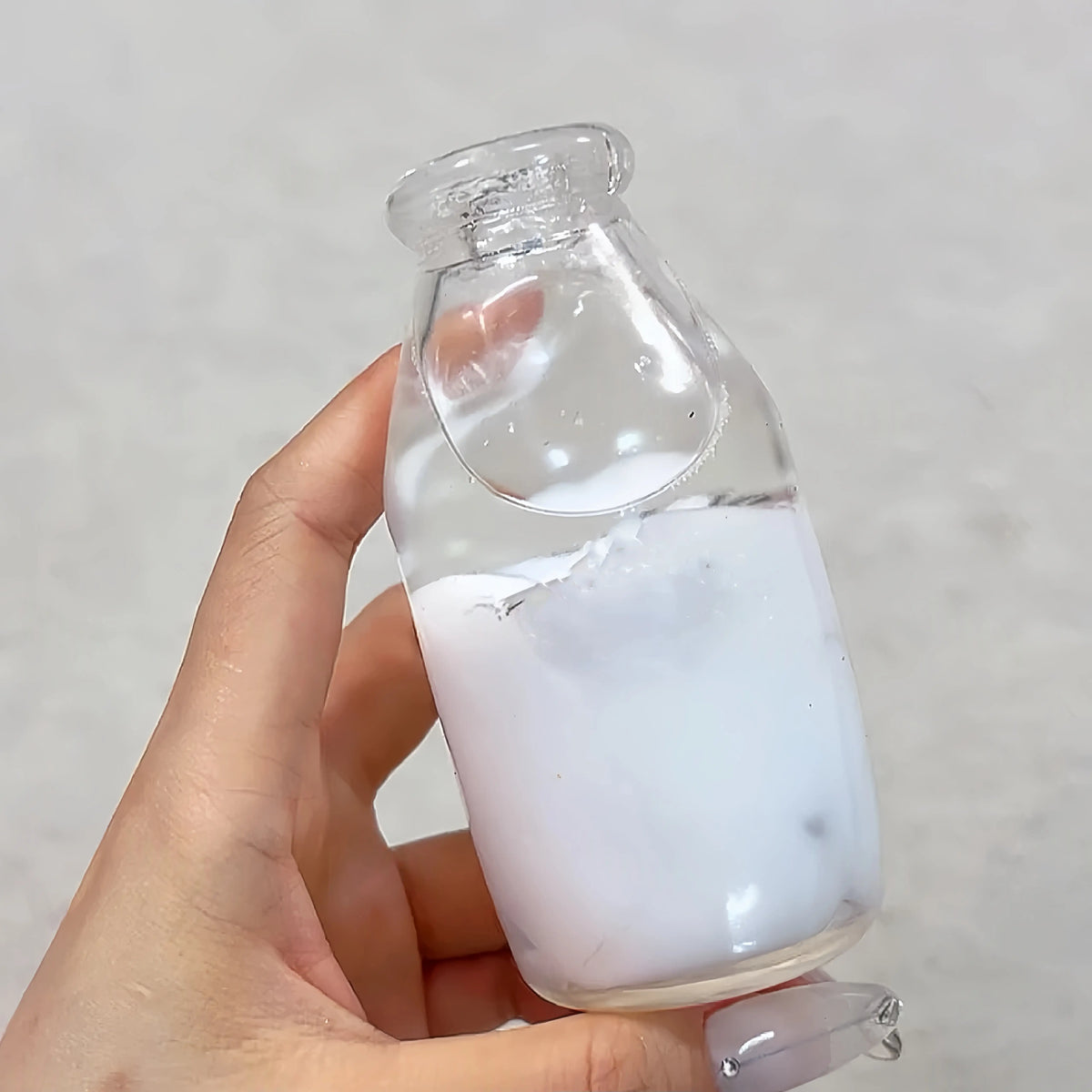 Adorable handmade clear bottle squishy ball with milk layered gel, stress relief desk toy from Lovesquishy.