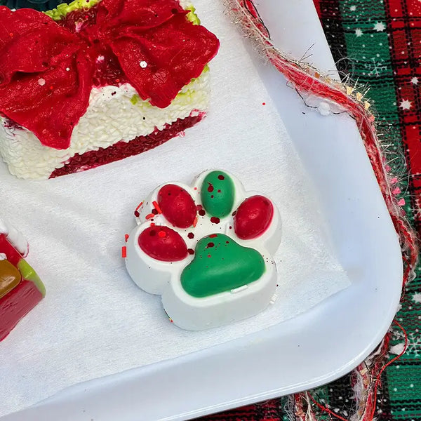 Red and green paw onigiri squishy with festive sprinkles; soft holiday stress relief toy from lovesquishy